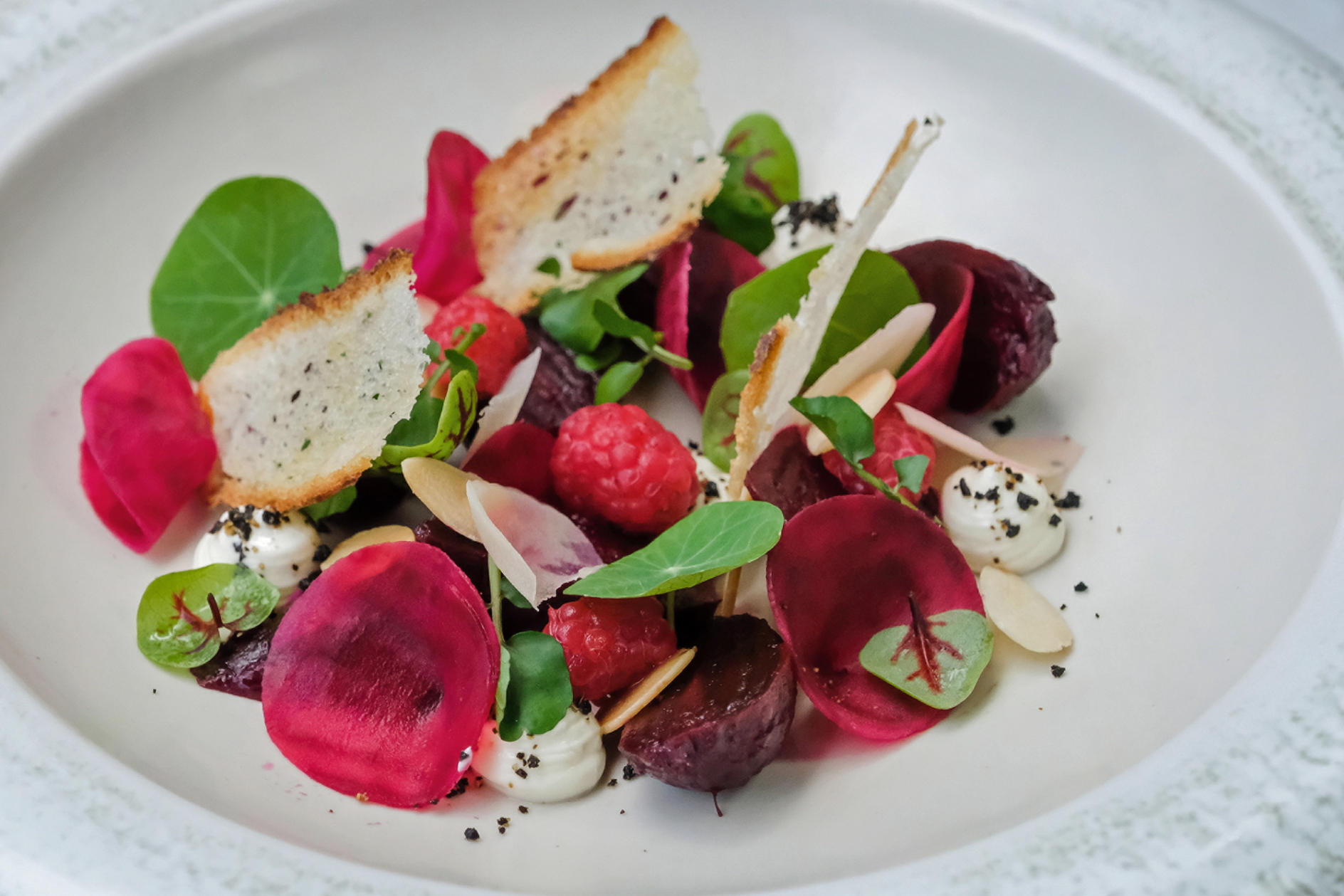 Beetroot and Goat’s Cheese Salad: The beetroot is presented two ways (roasted and pickled) with goat’s cheese puree, fresh sliced salak (local snakeskin fruit), whole raspberries, almond flakes and dehydrated ground olives.  Click to enlarge.