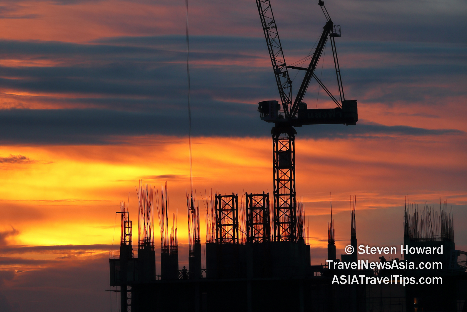 Construction and a beautiful, fiery sunset in Greater Bangkok, Thailand. Picture by Steven Howard of TravelNewsAsia.com Click to enlarge.