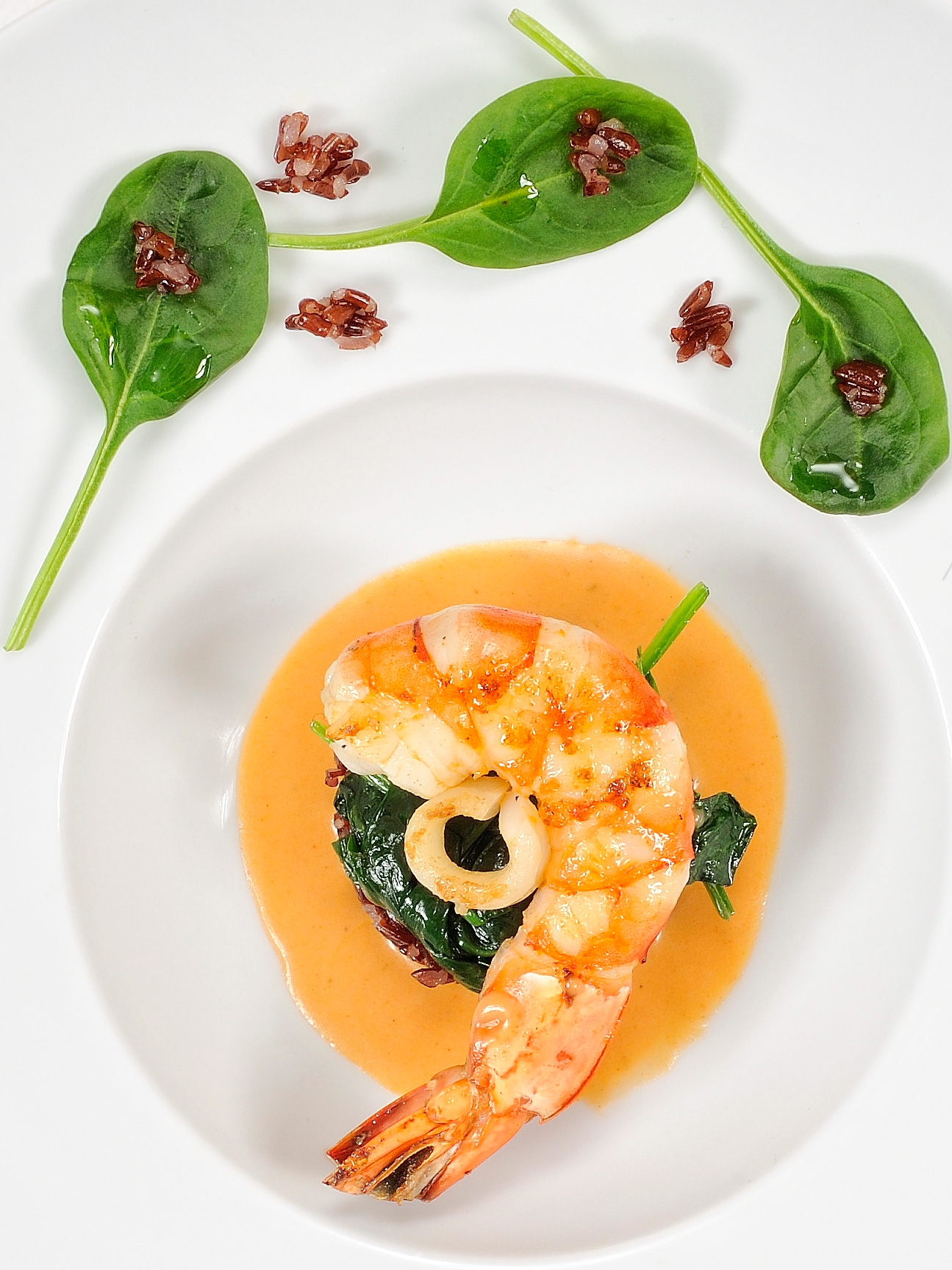 Shrimp in lobster sauce perfumed with tarragon, red rice and baby spinach. Click to enlarge.