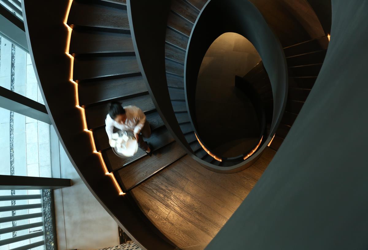Hotel employee walking down a spiral staircase. Picture: Swire Hotels. Click to enlarge.