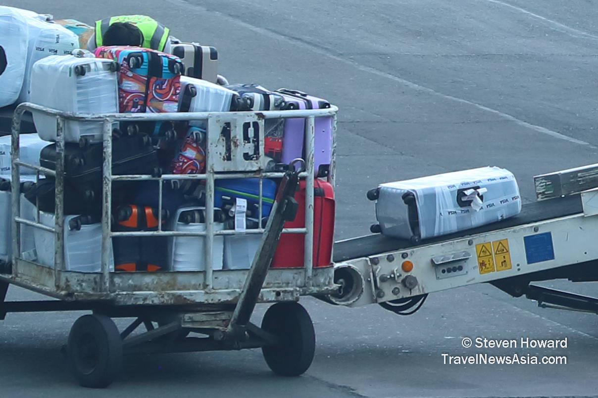 Baggage being manually loaded onto an aircraft. Picture by Steven Howard of TravelNewsAsia.com Click to enlarge.